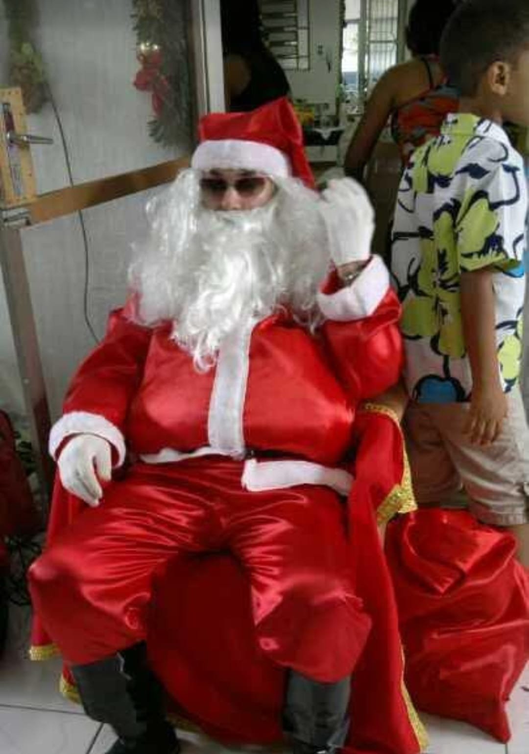 Papai Noel sentado ao lado dos presentes