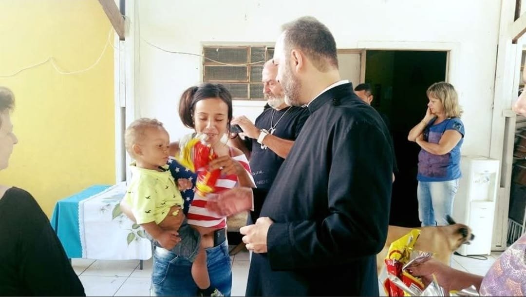 Mãe com criança no colo recebe presente