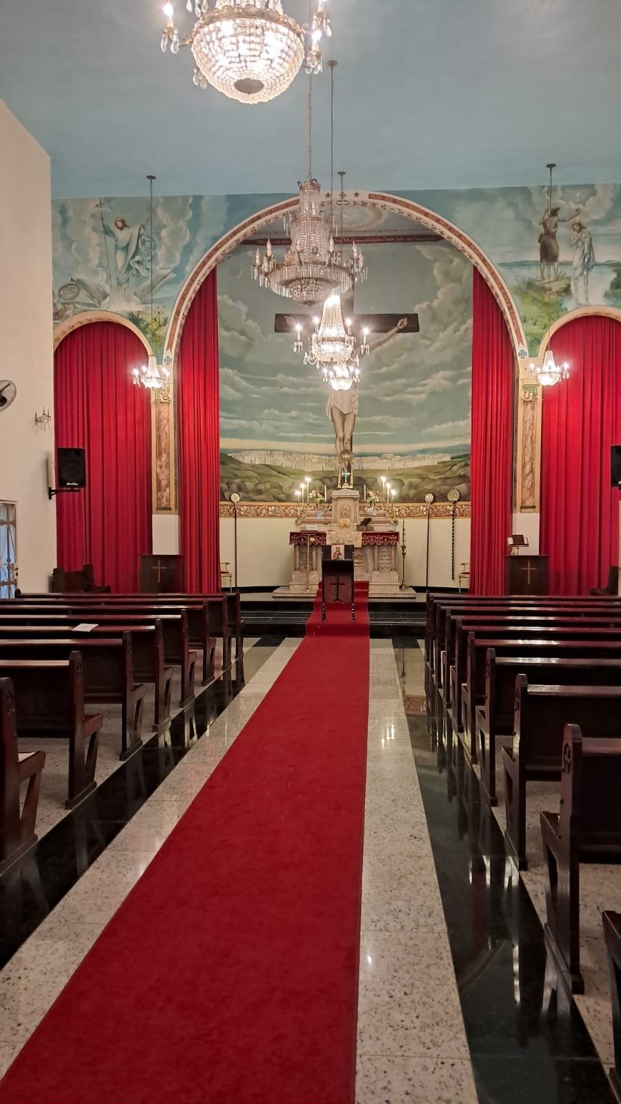 Nave da igreja com o corredor central e o altar ao fundo