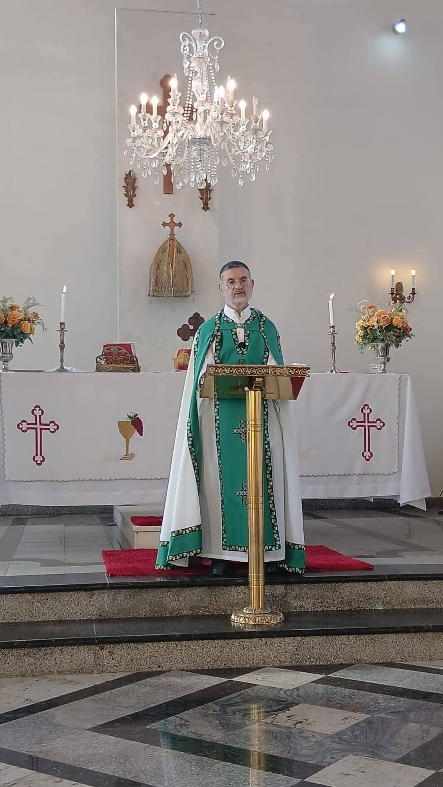 Sacerdote em vestes verdes no ambão, diante do altar